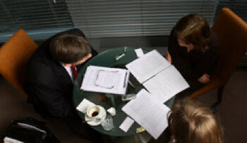 aerial view of three people discussing documents