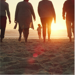 Full length shot of a senior group of friends enjoying a day on the beach with their grandchildren at sunset